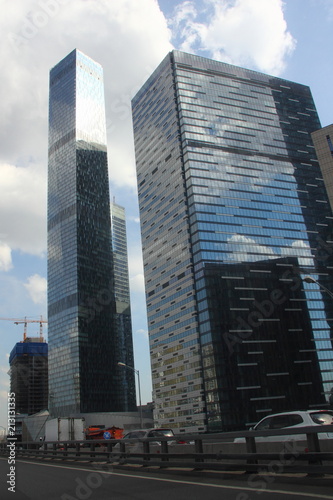 View from road of the glass skyscrapers in Moscow - business center Moscow city in the afternoon against the blue sky with clouds
