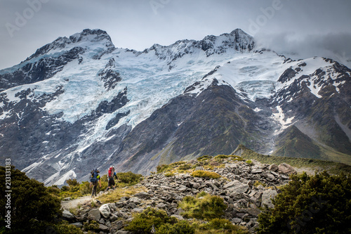 Two climbers head up the track towards the mountain range for a weekend adventure