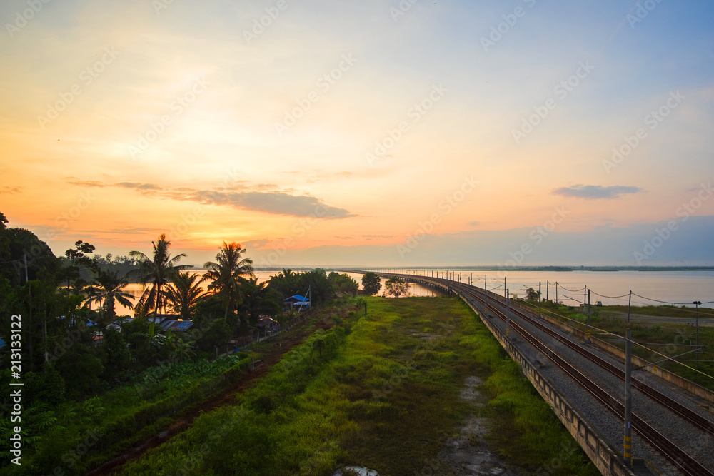 Beautiful Sunrise over Floating Railway at ‘Bukit Merah,Malaysia’ . Soft Focus,Motion Blur due to Long Exposure.Visible Noise due to High ISO. Beautiful Sunrise over Floating Railway at ‘Bukit Merah,Malaysia’ . Soft Focus,Motion Blur due to Long Exposure.Visible Noise due to High ISO.