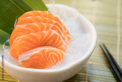 Raw salmon slice or salmon sashimi in Japanese style fresh serve on ice in bowl.