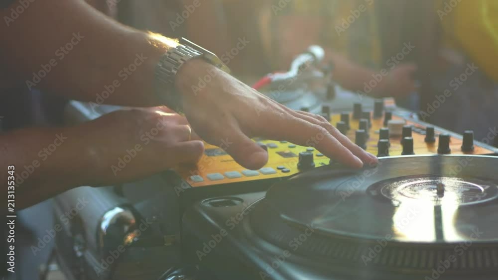 close up dj hand scratching vinyl record on turntable on a party