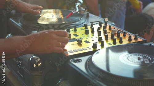 close up dj hand scratching vinyl record on turntable on a party