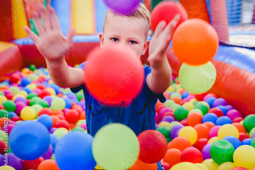 Fototapeta Inflatable castle full of colored balls for children to jump