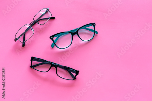 Glasses concept. Set of glasses with different eyeglass frame and transparent lenses on pink background top view copy space