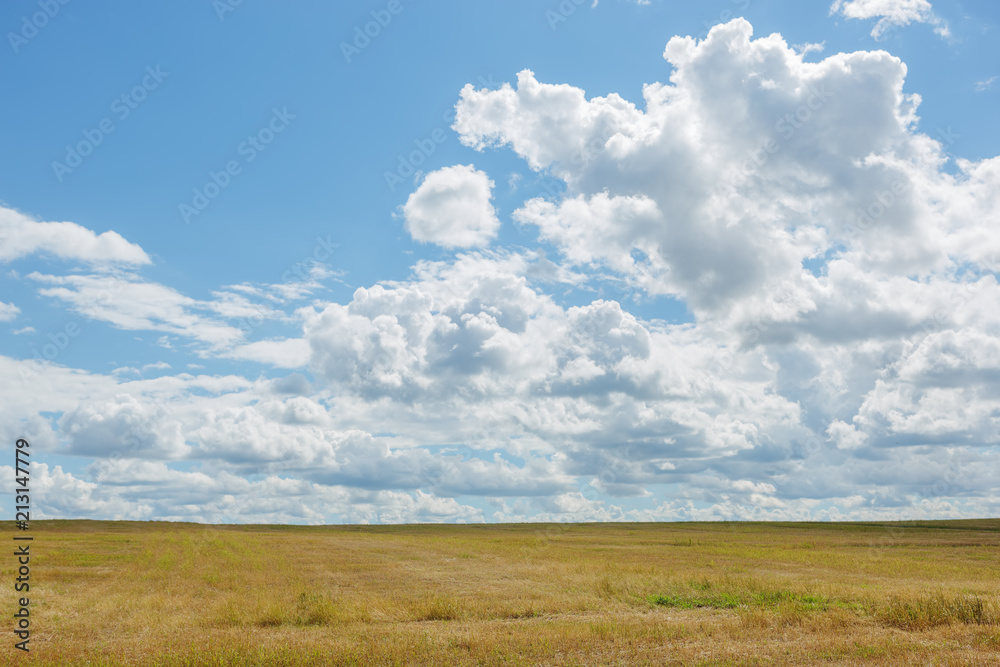 Clouds over a field of mowed grass