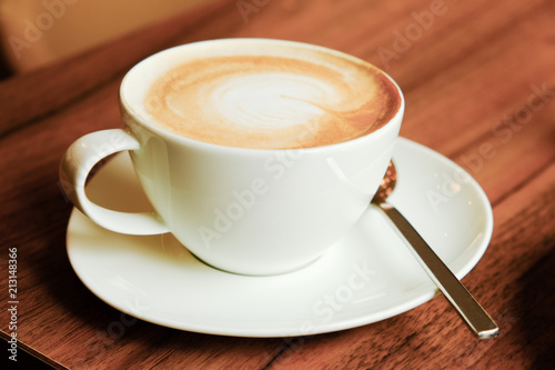 Cup of cappuccino on wooden background.