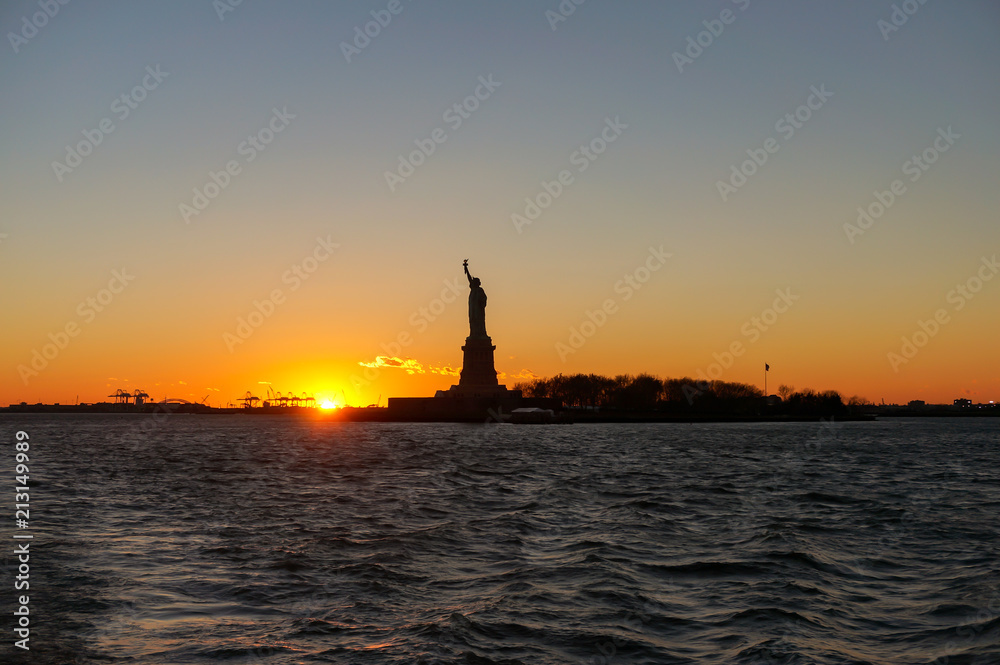 Sunset view of Liberty Statue silhouette from Ellis Island Ferry Tour‎