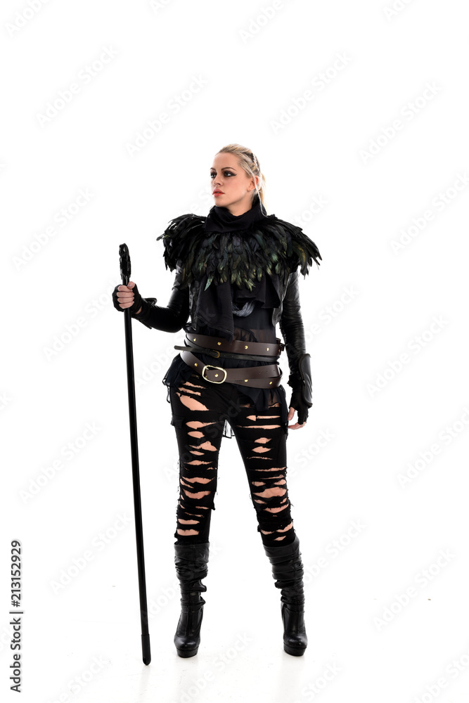 full length portrait of blonde girl wearing black gothic outfit, holding a staff. standing pose, isolated on white studio background. full length portrait of blonde girl wearing black gothic outfit, holding a staff. standing pose, isolated on white studio background.