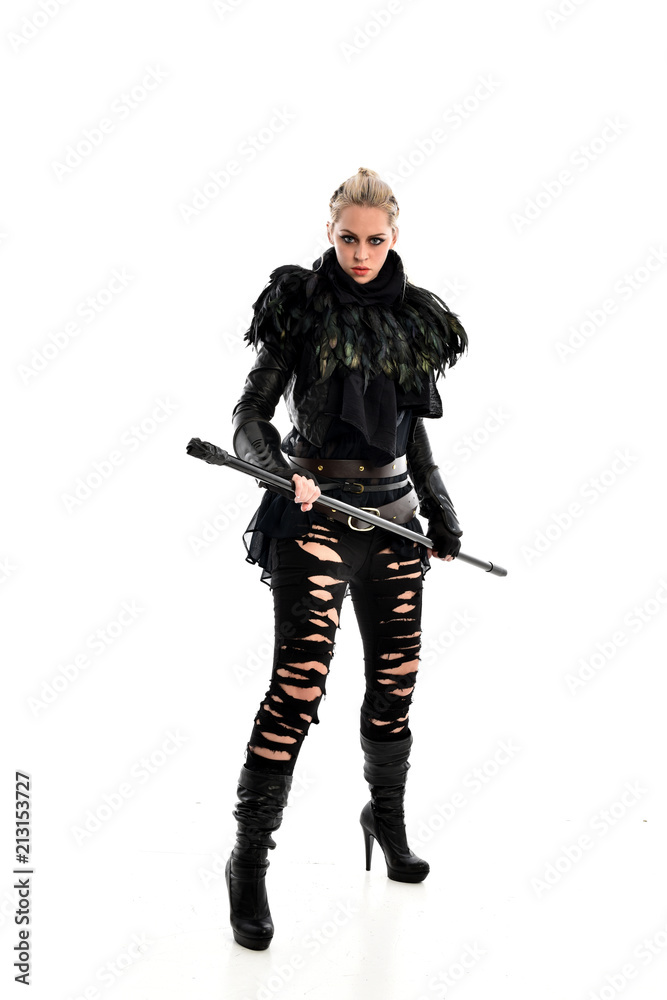 full length portrait of blonde girl wearing black gothic outfit, holding a staff. standing pose, isolated on white studio background. full length portrait of blonde girl wearing black gothic outfit, holding a staff. standing pose, isolated on white studio background.