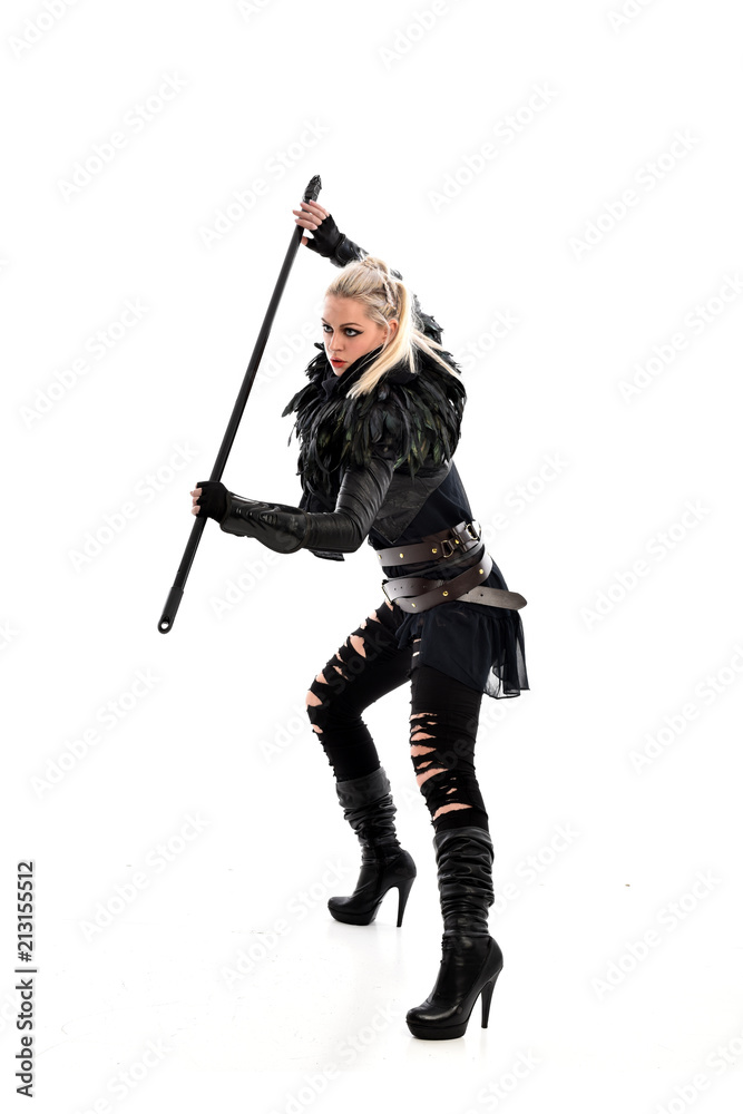 full length portrait of blonde girl wearing black gothic outfit, holding a staff. standing pose, isolated on white studio background. full length portrait of blonde girl wearing black gothic outfit, holding a staff. standing pose, isolated on white studio background.
