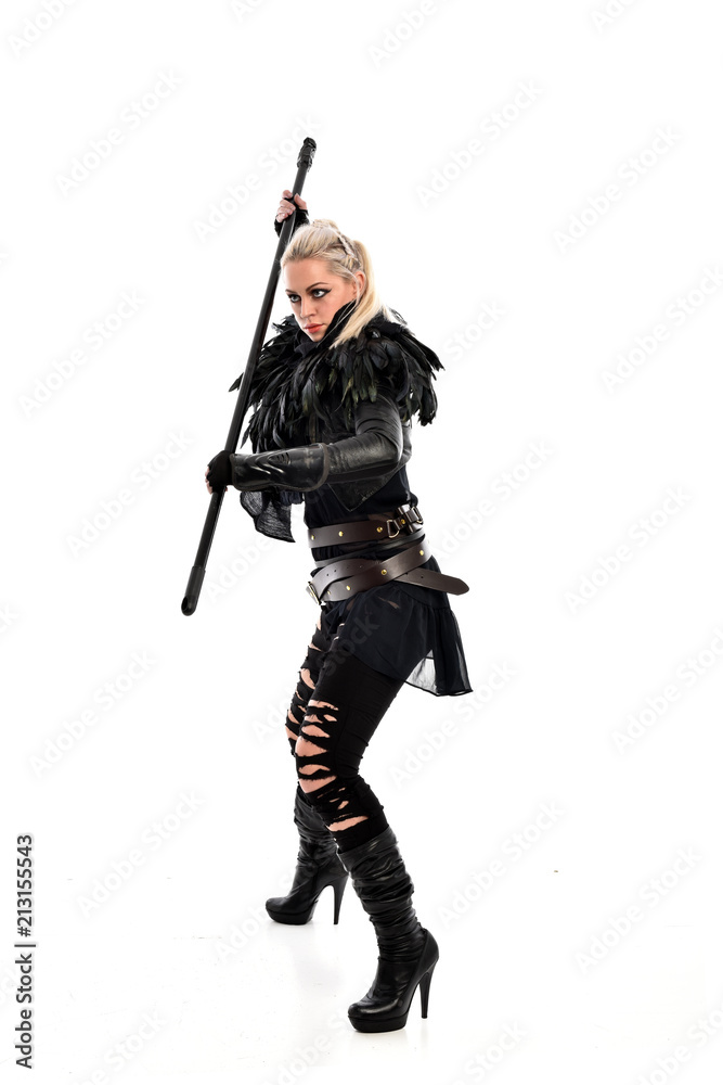full length portrait of blonde girl wearing black gothic outfit, holding a staff. standing pose, isolated on white studio background. full length portrait of blonde girl wearing black gothic outfit, holding a staff. standing pose, isolated on white studio background.