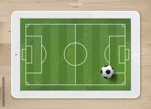 Soccer football ball in soccer field area on tablet display with wood texture background. For create soccer game and soccer football tactic idea. Vector.