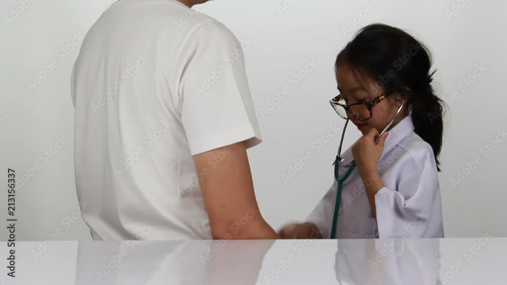 Asian little girl playing as doctor examining her father with Stethoscope Asian little girl playing as doctor examining her father with Stethoscope