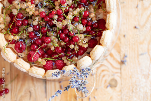 Sharlotta cake with blueberries, decorated with raspberries, red currant, white currant and lavender photo