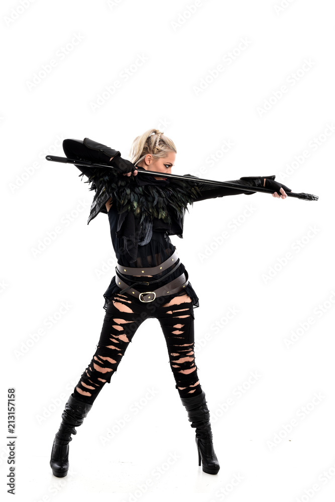 full length portrait of blonde girl wearing black gothic outfit, holding a staff. standing pose, isolated on white studio background. full length portrait of blonde girl wearing black gothic outfit, holding a staff. standing pose, isolated on white studio background.