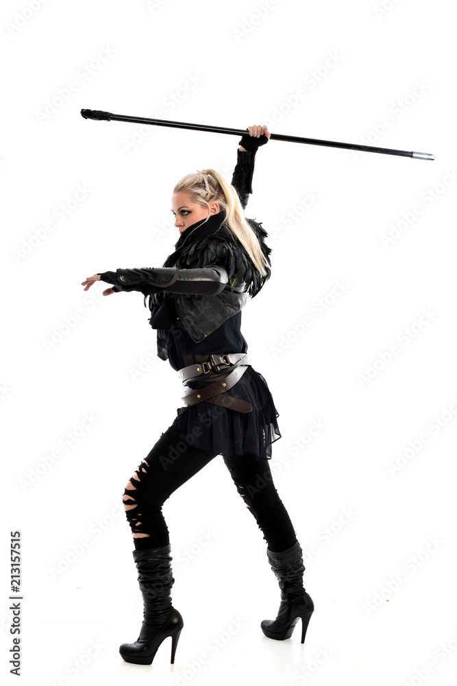 full length portrait of blonde girl wearing black gothic outfit, holding a staff. standing pose, isolated on white studio background. full length portrait of blonde girl wearing black gothic outfit, holding a staff. standing pose, isolated on white studio background.