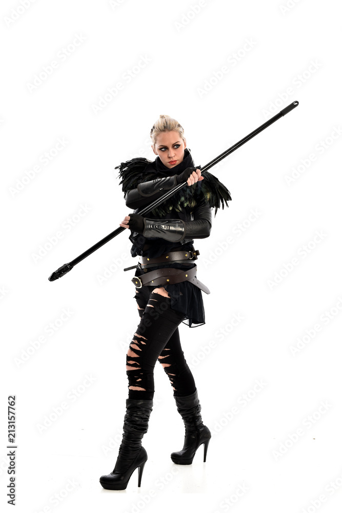 full length portrait of blonde girl wearing black gothic outfit, holding a staff. standing pose, isolated on white studio background. full length portrait of blonde girl wearing black gothic outfit, holding a staff. standing pose, isolated on white studio background.