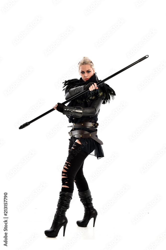 full length portrait of blonde girl wearing black gothic outfit, holding a staff. standing pose, isolated on white studio background. full length portrait of blonde girl wearing black gothic outfit, holding a staff. standing pose, isolated on white studio background.