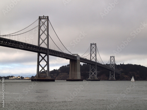 Boat sail by the San Francisco side of Bay Bridge on a foggy day