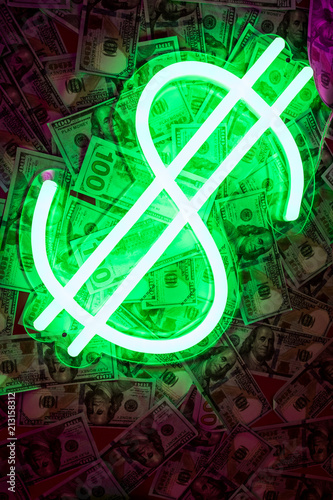 Neon dollar sign on a bed of 100 USD bills