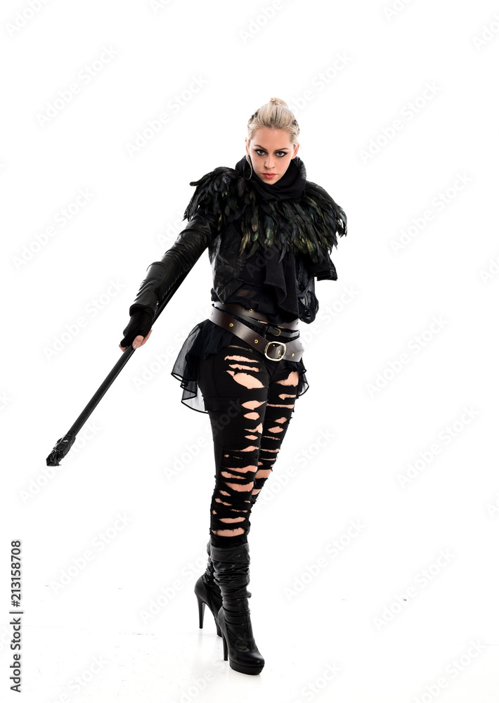 full length portrait of blonde girl wearing black gothic outfit, holding a staff. standing pose, isolated on white studio background. full length portrait of blonde girl wearing black gothic outfit, holding a staff. standing pose, isolated on white studio background.