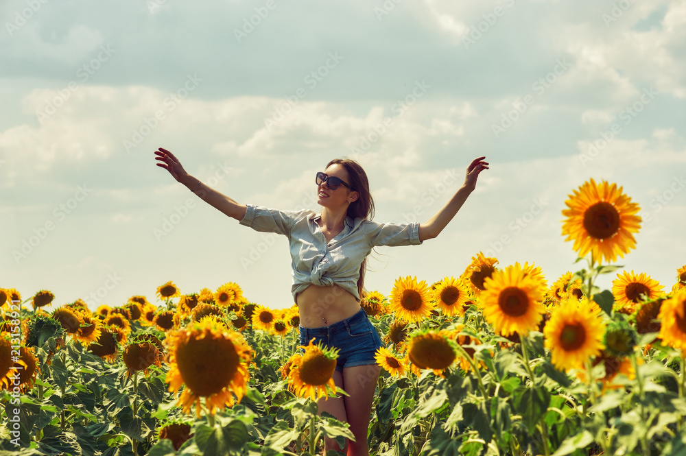Young attractive girl in the field with sunflowers .Girl on a walk on a summer day in the countryside Young attractive girl in the field with sunflowers .Girl on a walk on a summer day in the countryside