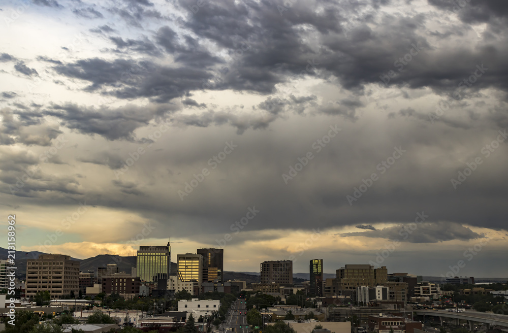 Boise, Idaho, USA. Cityscape with a view along Grove Street and a dramatic sunset in summertime. Downtown streets and skyscrapers and the Boise Foothills.
