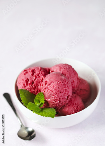 Raspberry ice cream in white bowl