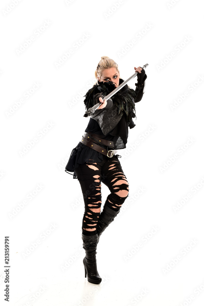 full length portrait of blonde girl wearing black gothic outfit, holding a staff. standing pose, isolated on white studio background. full length portrait of blonde girl wearing black gothic outfit, holding a staff. standing pose, isolated on white studio background.