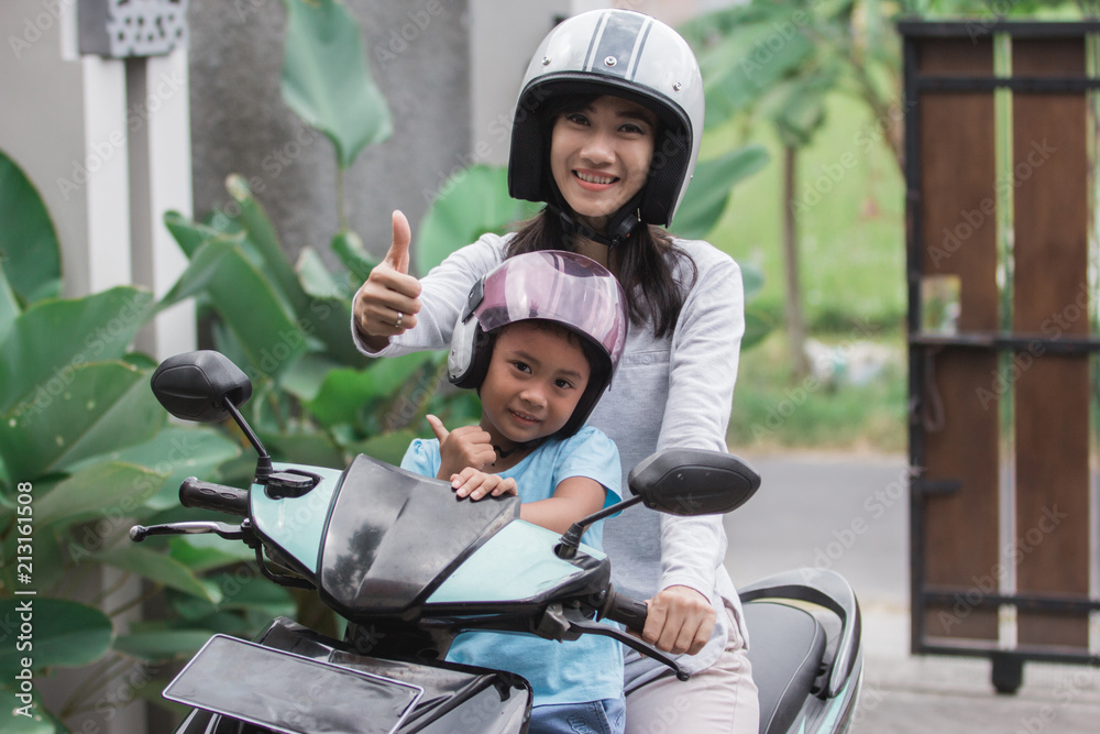 mother and daughter riding motorbike scooter