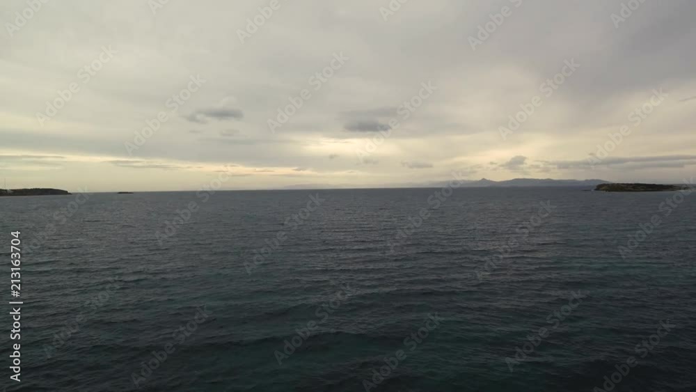 Flying over the sea on a cloudy day. Small island on the horizon. Flying over the sea on a cloudy day. Small island on the horizon.