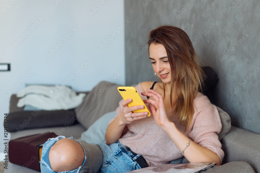 Pretty girl using her smartphone on couch at home Pretty girl using her smartphone on couch at home