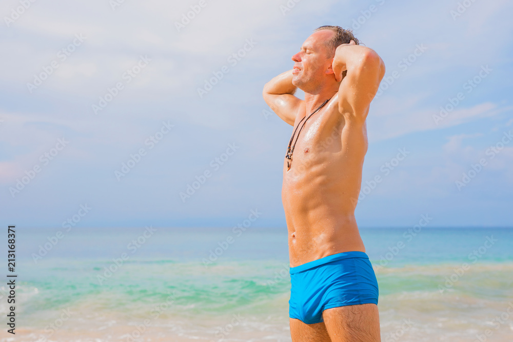 Handsome man enjoying sun on the beach