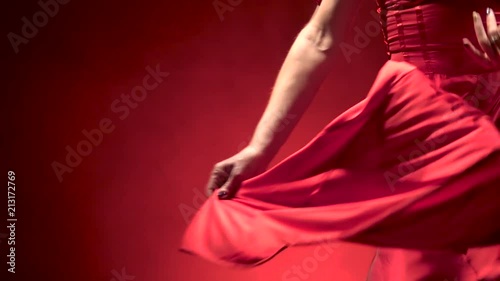 Dancer in the rhythm of the music develops her skirt. Black background. Close up. Slow motion