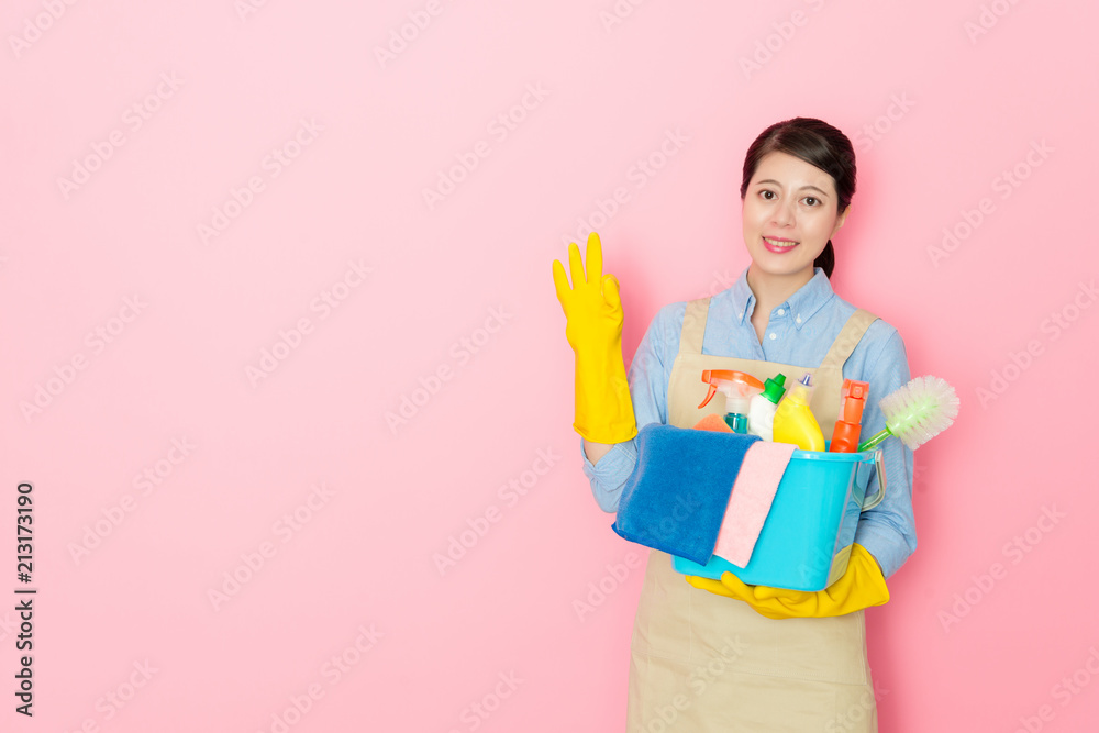 woman holding cleaning stuffs with toothy smiler woman holding cleaning stuffs with toothy smiler