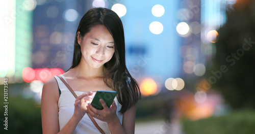 Photography Woman works on mobile phone in city at night
