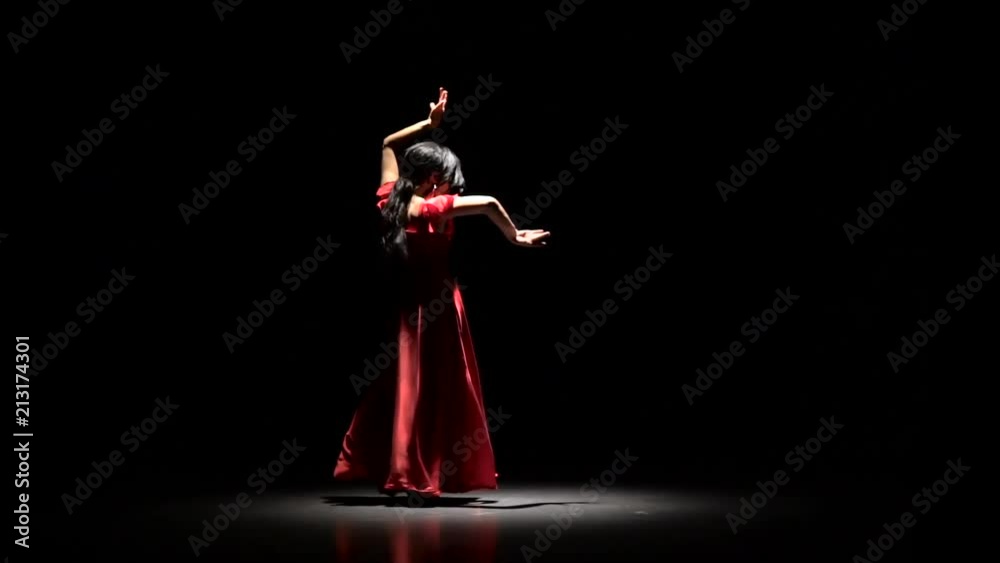 Girl in dress the dark room performs elegant movements with her hands in dance. Black background. Slow motion Girl in dress the dark room performs elegant movements with her hands in dance. Black background. Slow motion