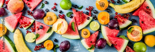 Obraz  z motywem Summer vitamin food concept, various fruit and berries watermelon peach mint plum apricots blueberry currant, creative flat lay on light blue background top view copy space