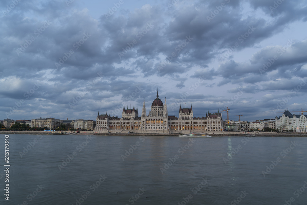 view of Parliament palace in front of the Danube river at sunset in Budapest, Hungary