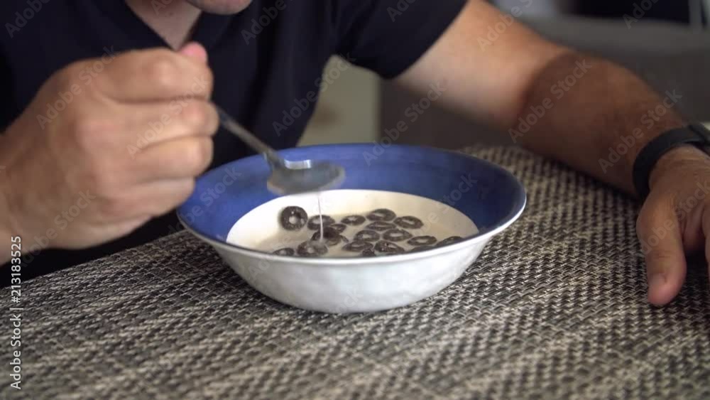 Close up insert shot of bowl with cereal and milk. Man takes a spoonful of cereal. Close up insert shot of bowl with cereal and milk. Man takes a spoonful of cereal.