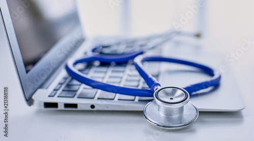 Stethoscope lying on a laptop keyboard in a concept of online medicine or troubleshooting the computer viewed low angle with copy space