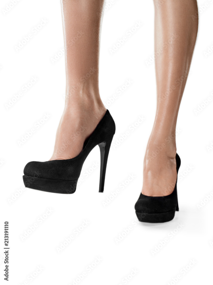 Tanned female legs in high heels isolated on white background. Tanned female legs in high heels isolated on white background.