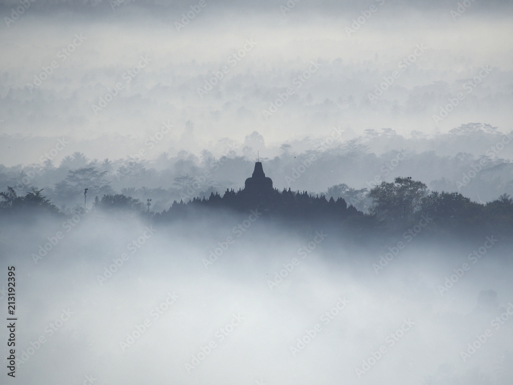 Borobudur Temple in a beautiful foggy sunrise seen from Punthuk Setumbu Hill