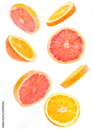 sliced flying grapefruit and orange falling isolated on white background