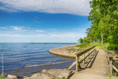 Fototapeta Naklejka Na Ścianę i Meble -  Rustic wooden bridge and lake Ontario. Blue sky. Rochester, USA