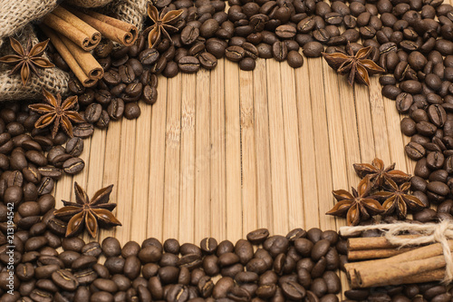 Background of coffee beans. Coffee texture. A place to write a text. Cinnamon sticks and cardamom. photo