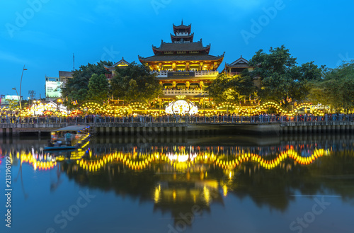Ho Chi Minh City, Vietnam - May 28, 2018: Night scene architecture temple along river at night decorated with bright lights, flags, flowers celebrate the Buddha's birthday in Ho Chi Minh City, Vietnam