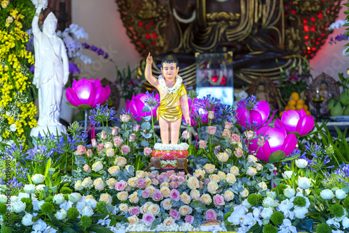 Buddha statue in temple decorated lights, colorful flowers on Buddha's birthday. A peacefull place to calm mine mind and soul in Ho Chi Minh city, Vietnam