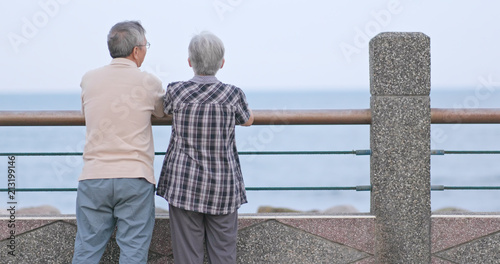 Old couple chatting and looking at the sea together