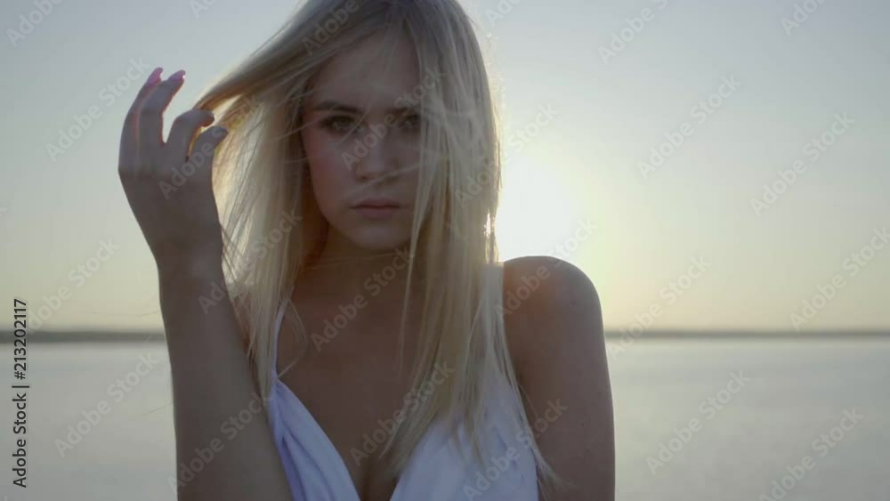 Blonde is touching up her hair Blonde is touching up her hair